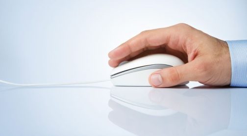 Male hand holding computer mouse with copy space